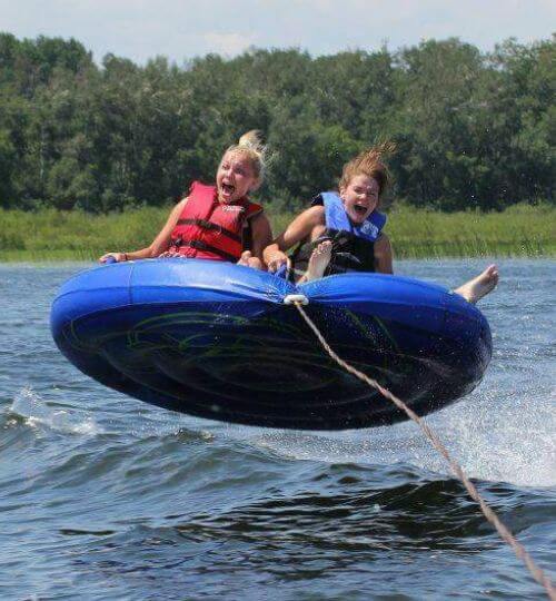 Two Resort Guests Scream with Joy While Water Tubing on Cass Lake