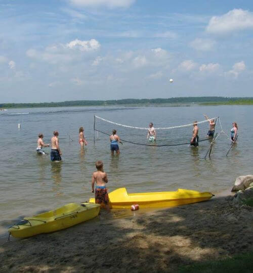 Resort Guests Play Water Volleyball on the Sandy Swimming Area on Allen's Bay