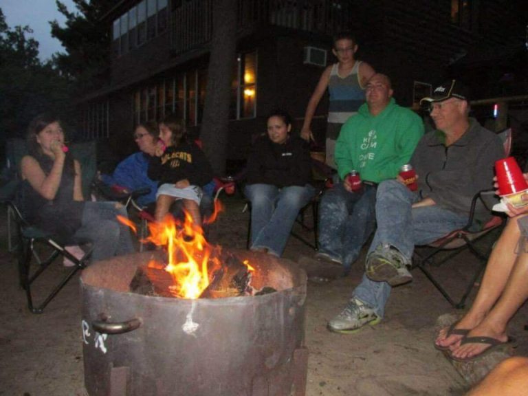 Sunset Cove Resort Guests Gather Around a Bonfire in Front of Allen's Bay Lodge & Grill