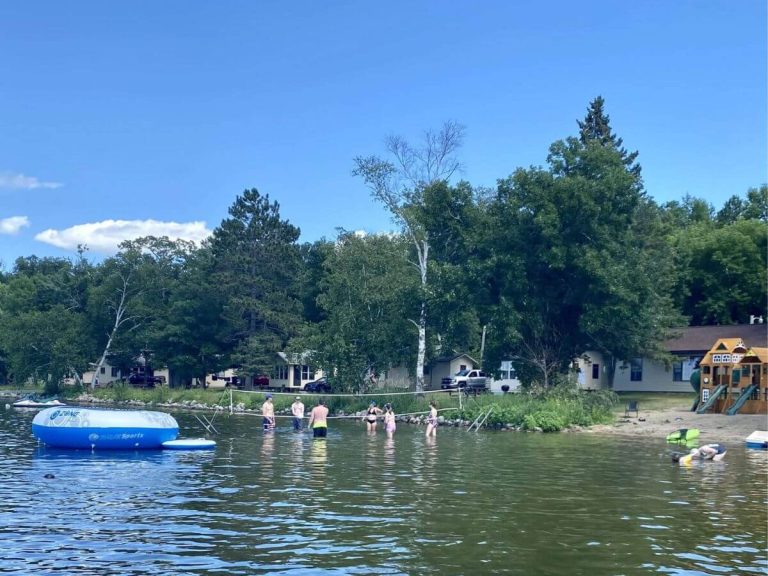 Resort Guests Play Water Volleyball in Front of Allen's Bay Lodge & Grill