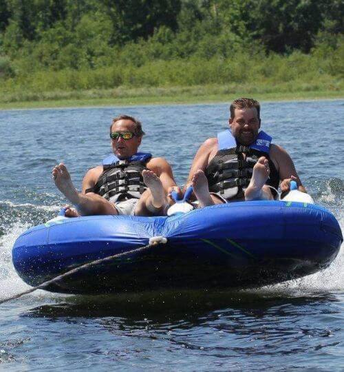 Two Adult Males Water Tubing Behind a Boat on Cass Lake