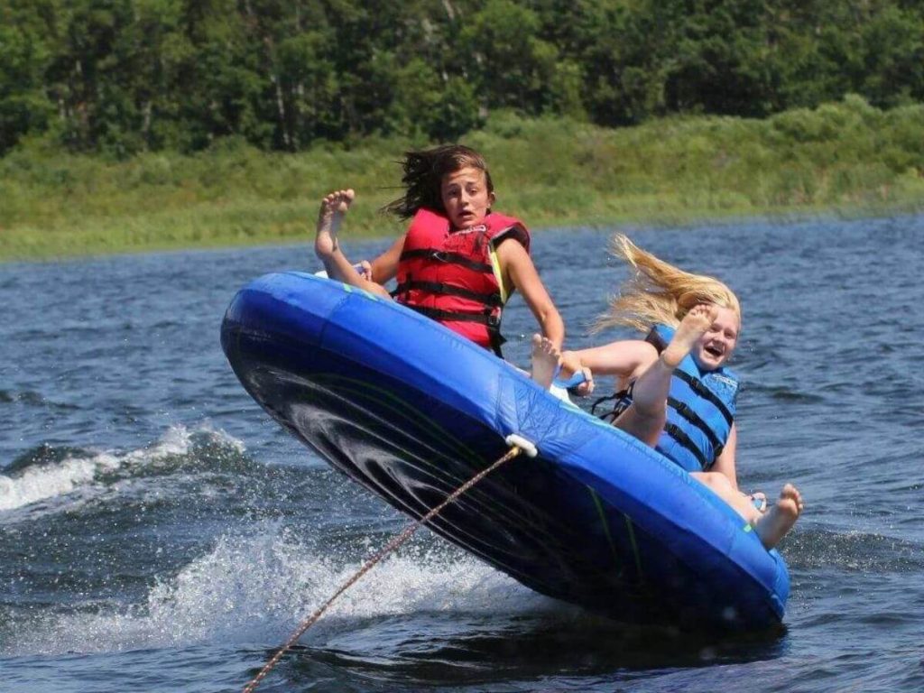 Two Females Hold On Tight While Extreme Water Tubing on Cass Lake