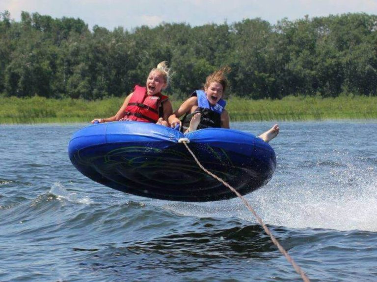 Two Resort Guests Scream with Joy While Water Tubing on Cass Lake